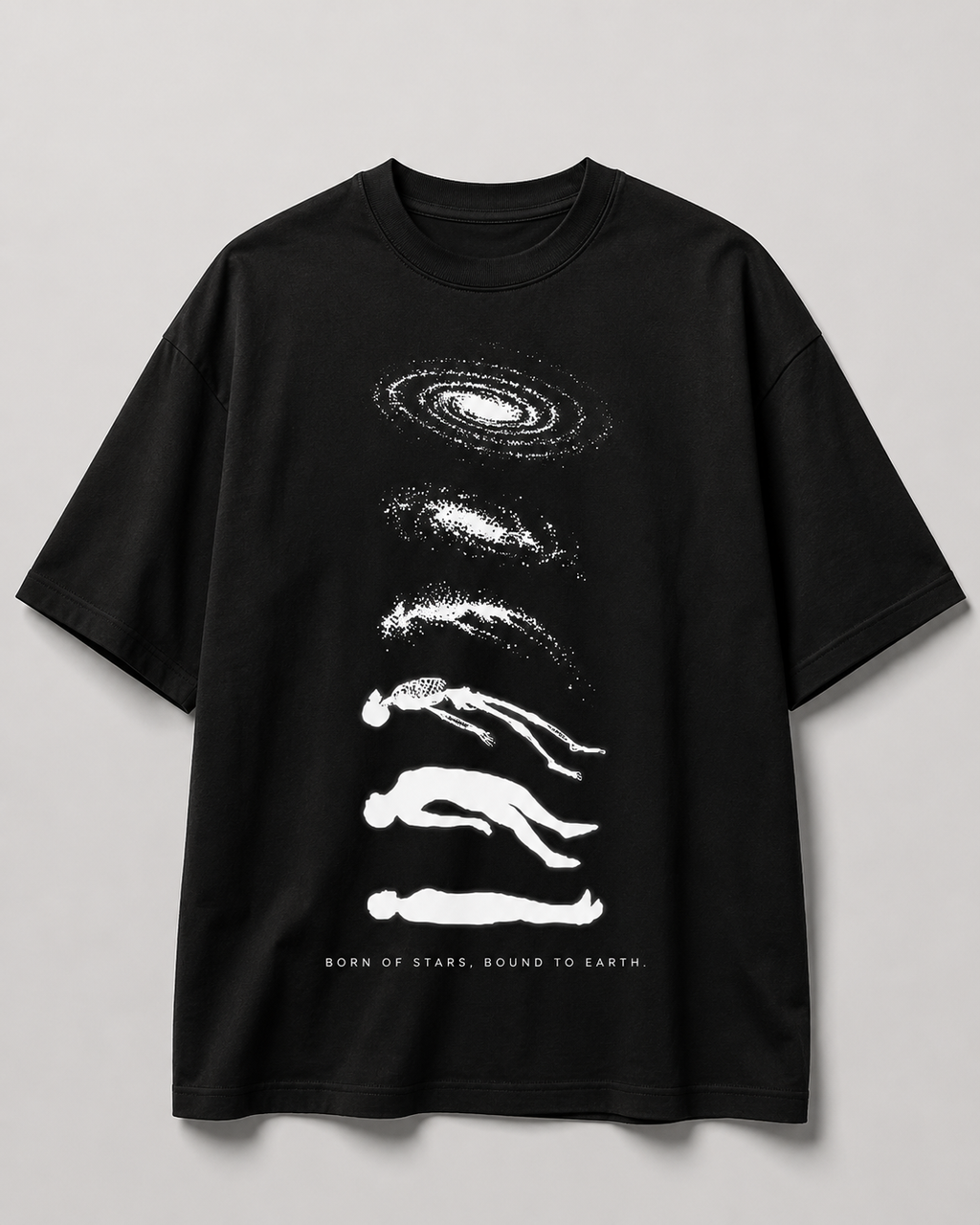 A black short-sleeve crewneck t-shirt with a white graphic print of stacked galaxies and human silhouettes, with the text 'BORN OF STARS, BOUND TO EARTH' printed at the bottom, shown against a neutral gray background.
