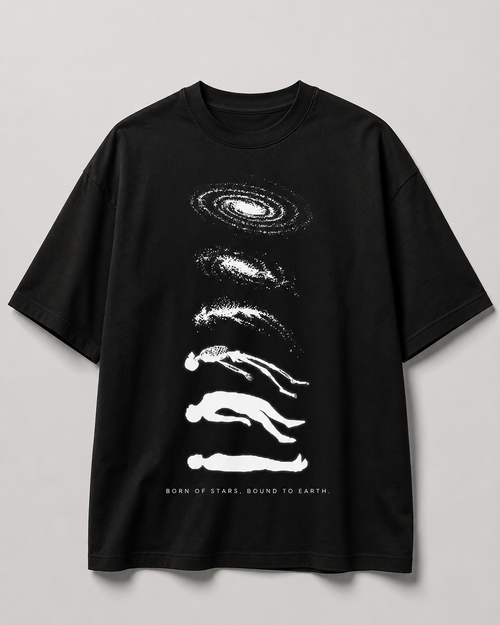 A black short-sleeve crewneck t-shirt with a white graphic print of stacked galaxies and human silhouettes, with the text 'BORN OF STARS, BOUND TO EARTH' printed at the bottom, shown against a neutral gray background.